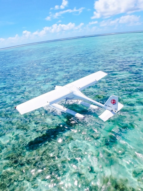 Seaplane flying over clear turquoise waters on the Eastern Underwater Waterfall route, Mauritius.