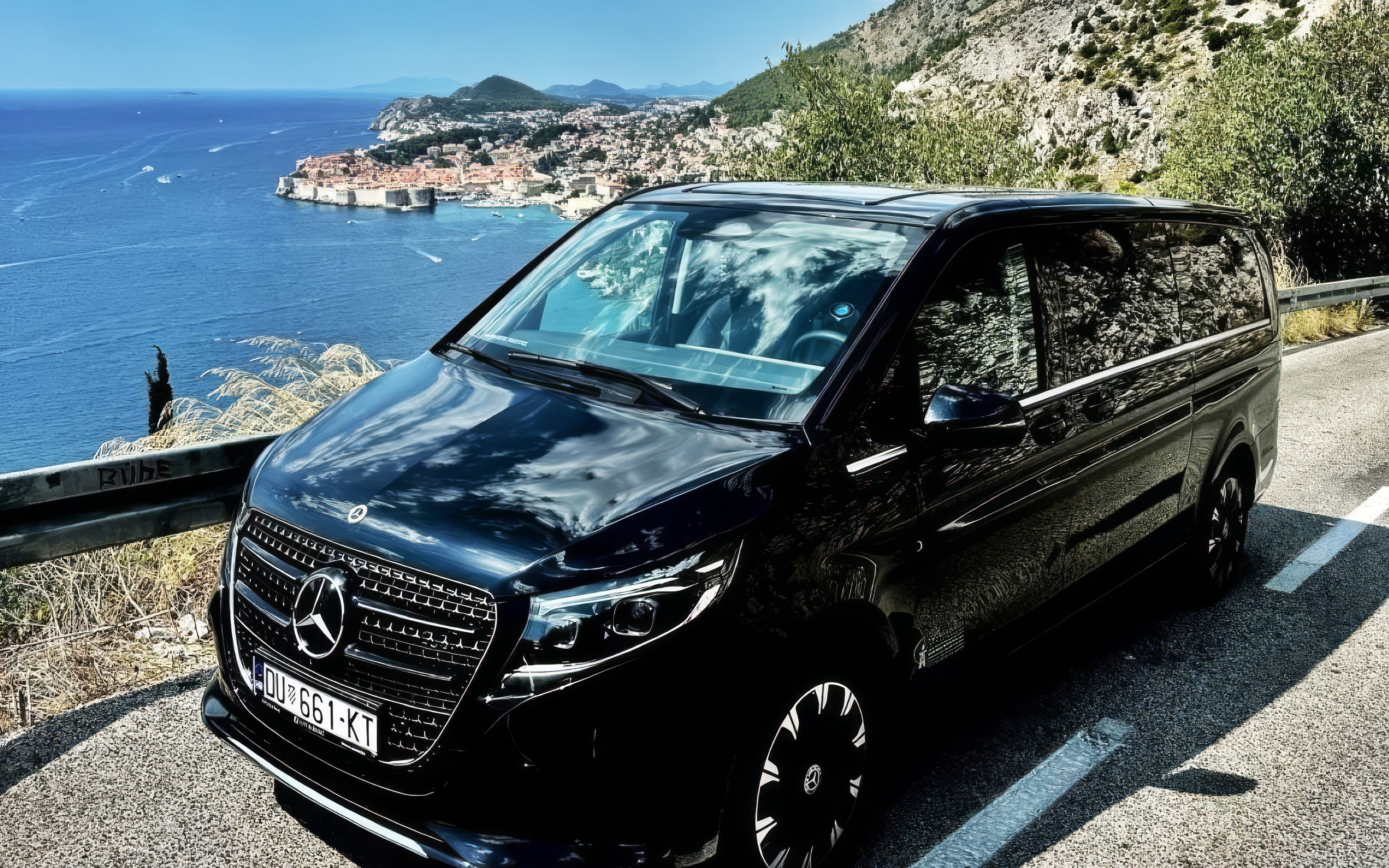 Mercedes E Class parked along the Adriatic coast with Dubrovnik in the background.