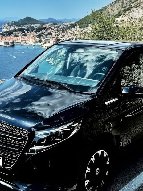 Mercedes E Class parked along the Adriatic coast with Dubrovnik in the background.