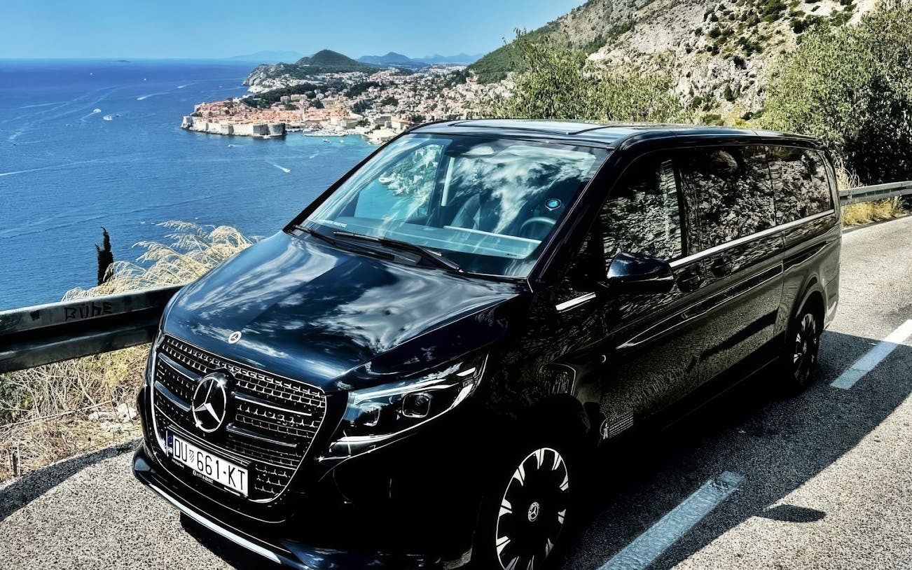 Mercedes E Class parked along the Adriatic coast with Dubrovnik in the background.