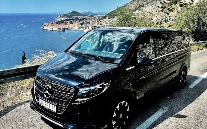 Mercedes E Class parked along the Adriatic coast with Dubrovnik in the background.