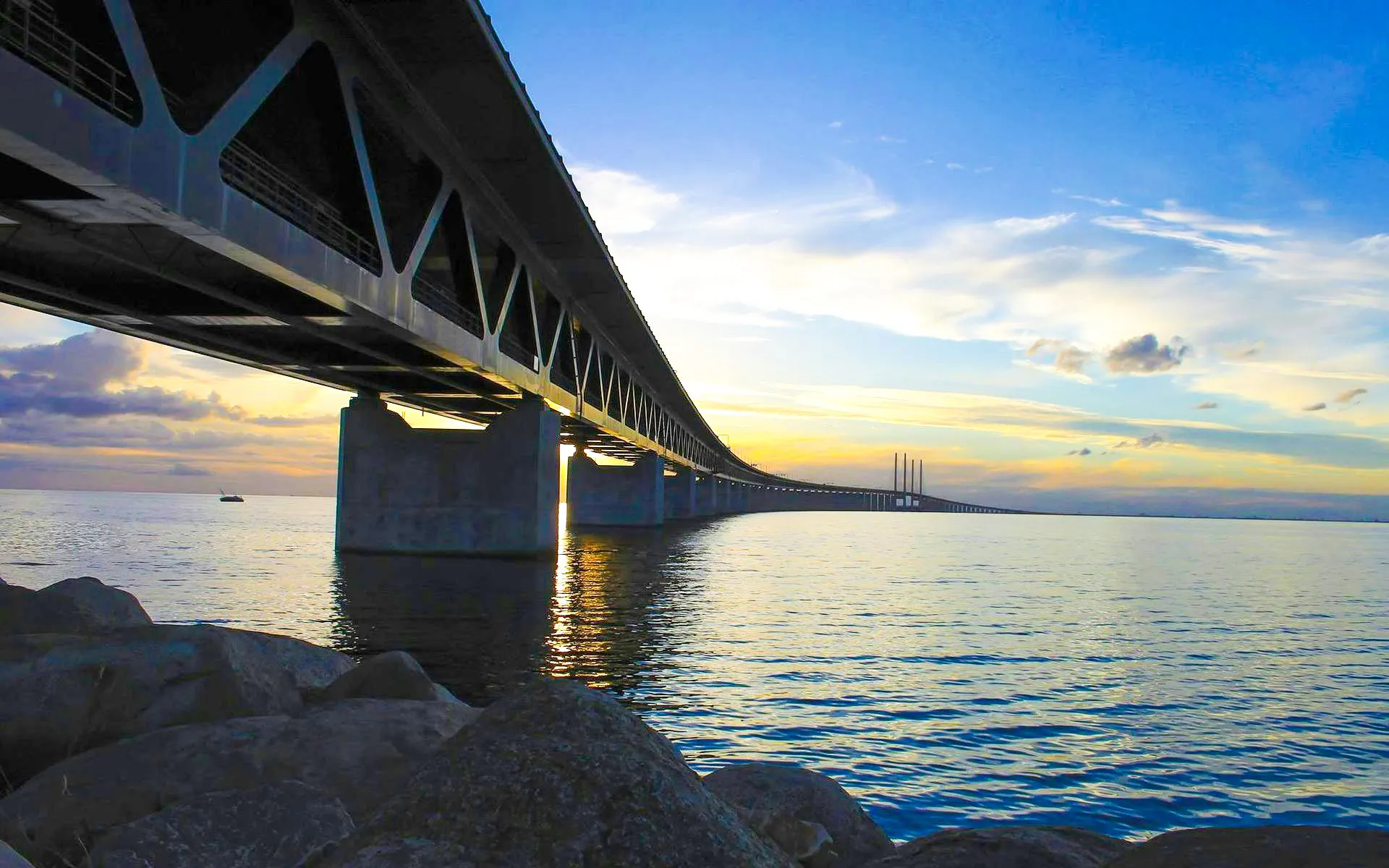 Øresund Bridge spanning over water at sunset, connecting Sweden and Denmark.