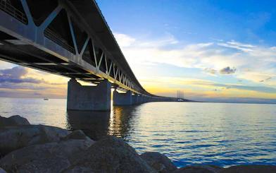 Øresund Bridge spanning over water at sunset, connecting Sweden and Denmark.