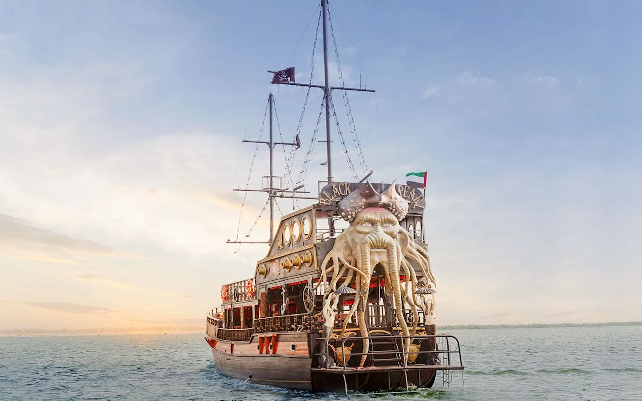 Luxury dhow with ornate design on Dubai Creek during sunset cruise.