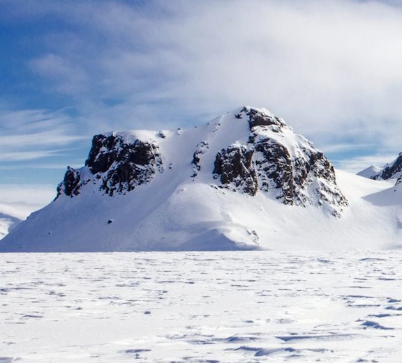 Langjökull Glacier with snow-covered peaks under a clear blue sky in Iceland.
