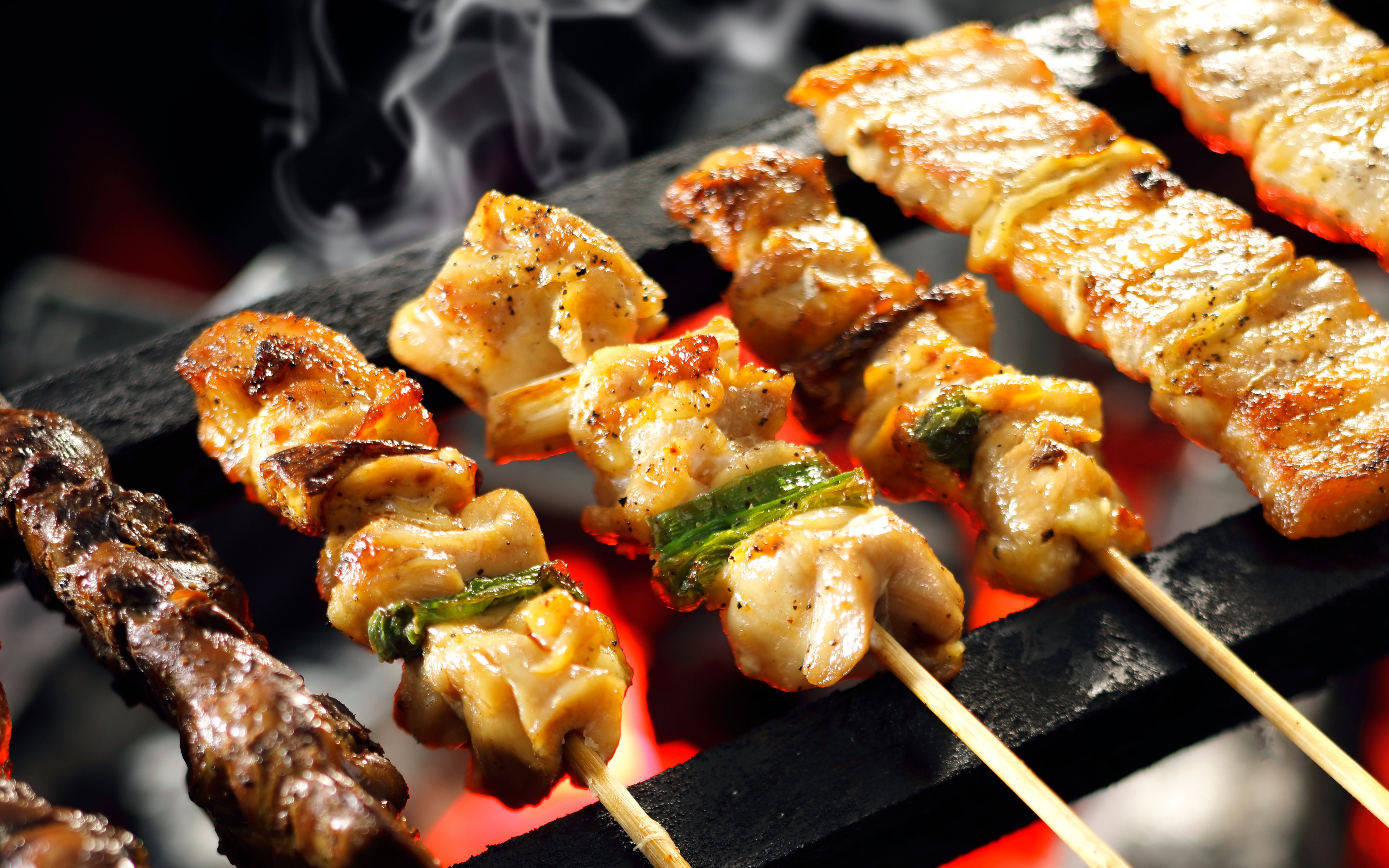 Grilled yakitori skewers cooking over hot coals in Japan.
