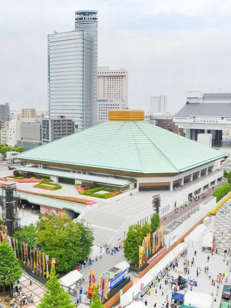 Sumo wrestling arena in Tokyo with surrounding cityscape and Tokyo Skytree in the background.
