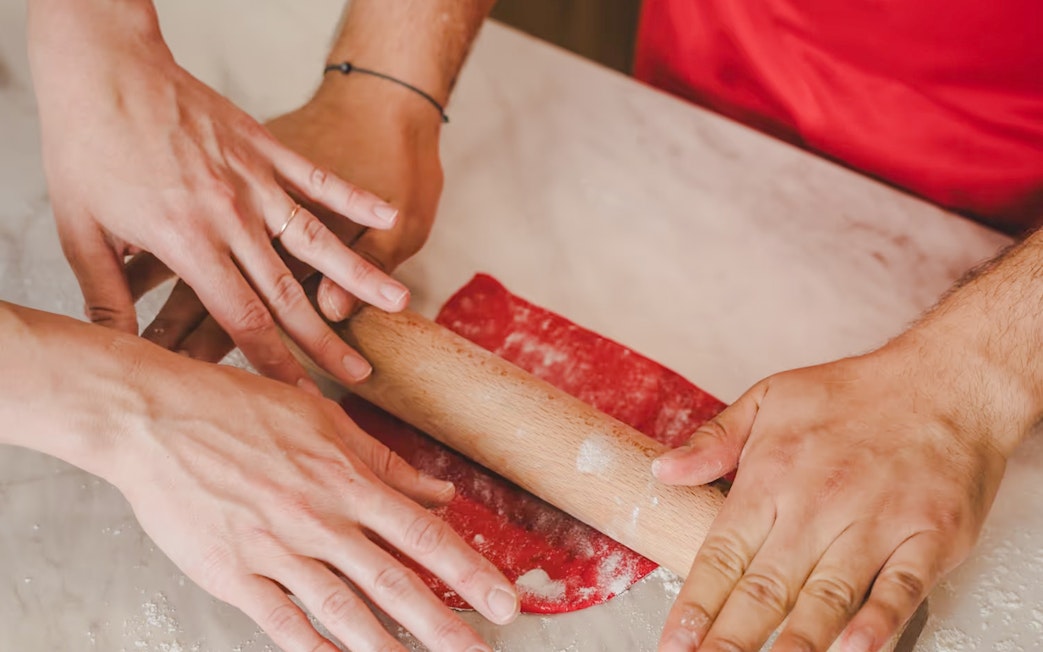 Hands rolling dough during Emily in Paris croissant-making workshop.