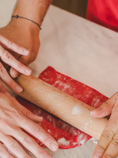 Hands rolling dough during Emily in Paris croissant-making workshop.