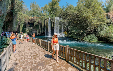 Woman walking by Duden Falls on Antalya sightseeing tour.