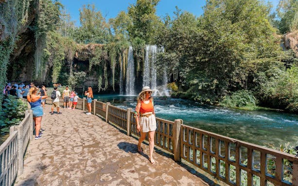 Woman walking by Duden Falls on Antalya sightseeing tour.