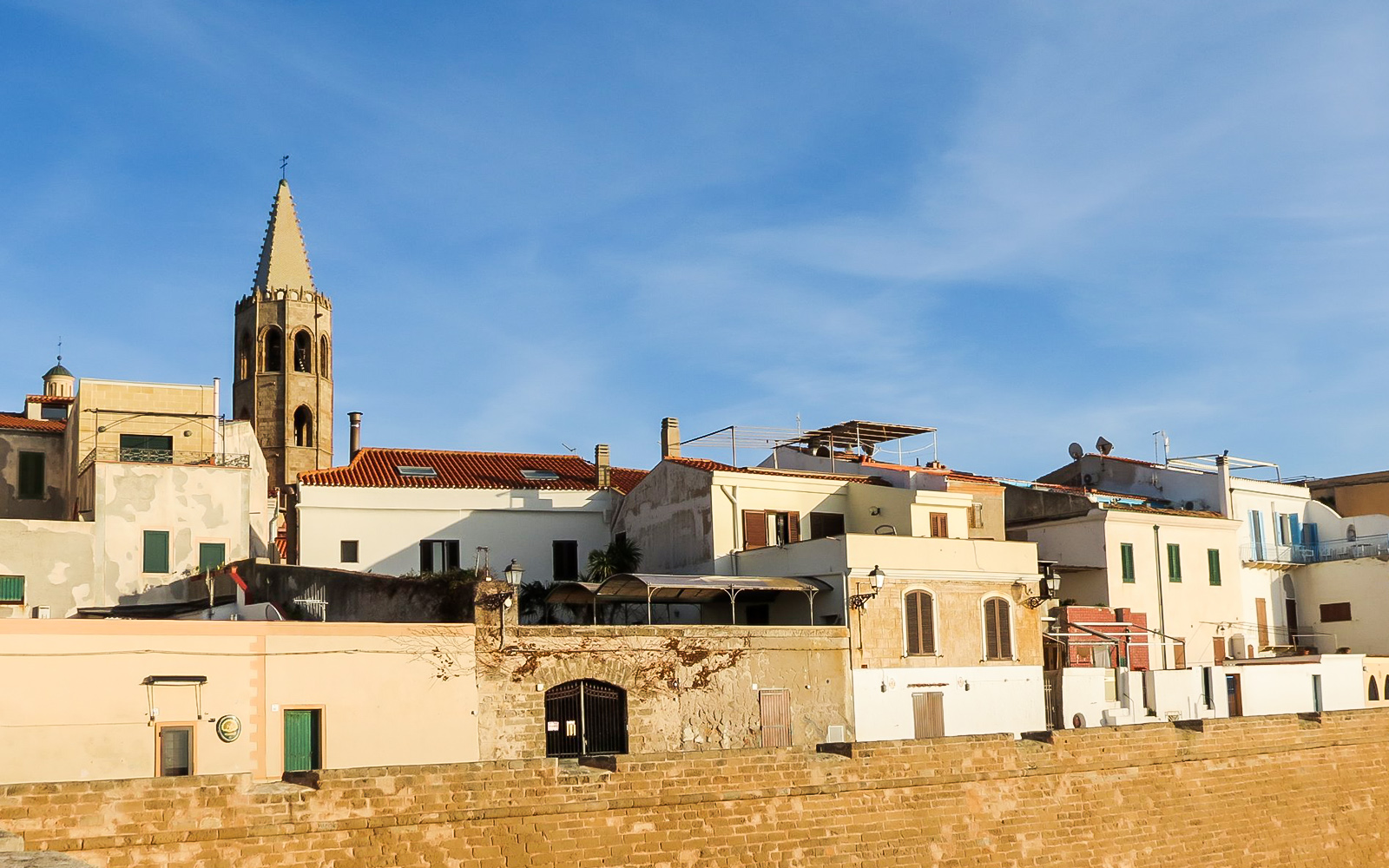 Alghero historic center with bell tower and traditional buildings.
