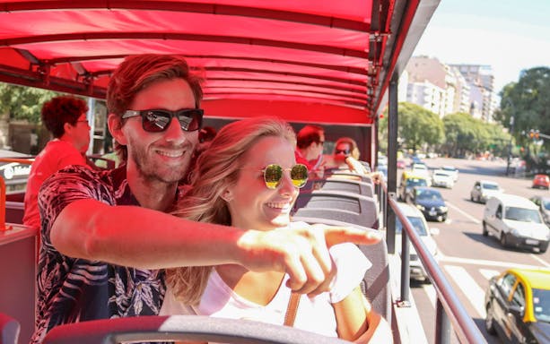 Couple enjoying city views from HOHO bus in Buenos Aires.