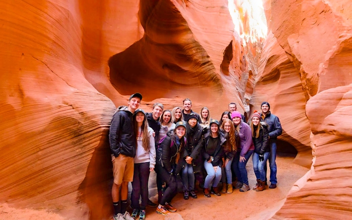 Group of tourists exploring Secret Antelope Canyon's sandstone formations.