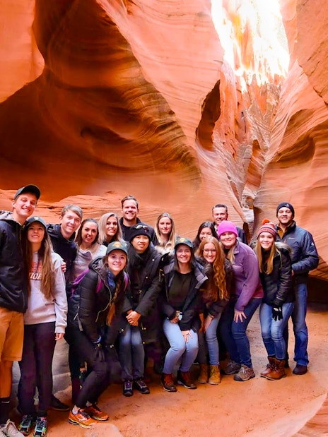 Group of tourists exploring Secret Antelope Canyon's sandstone formations.