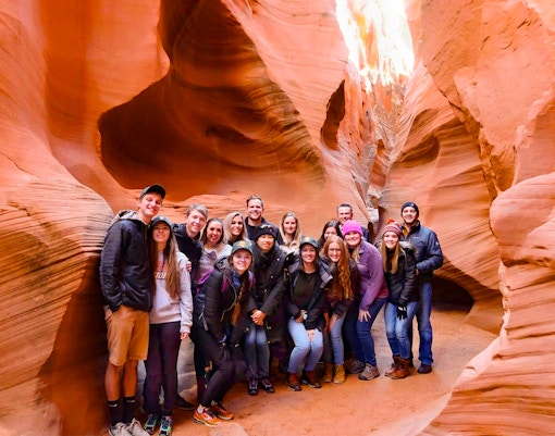 Group of tourists exploring Secret Antelope Canyon's sandstone formations.