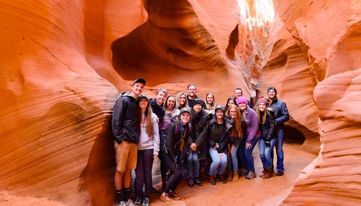 Group of tourists exploring Secret Antelope Canyon's sandstone formations.