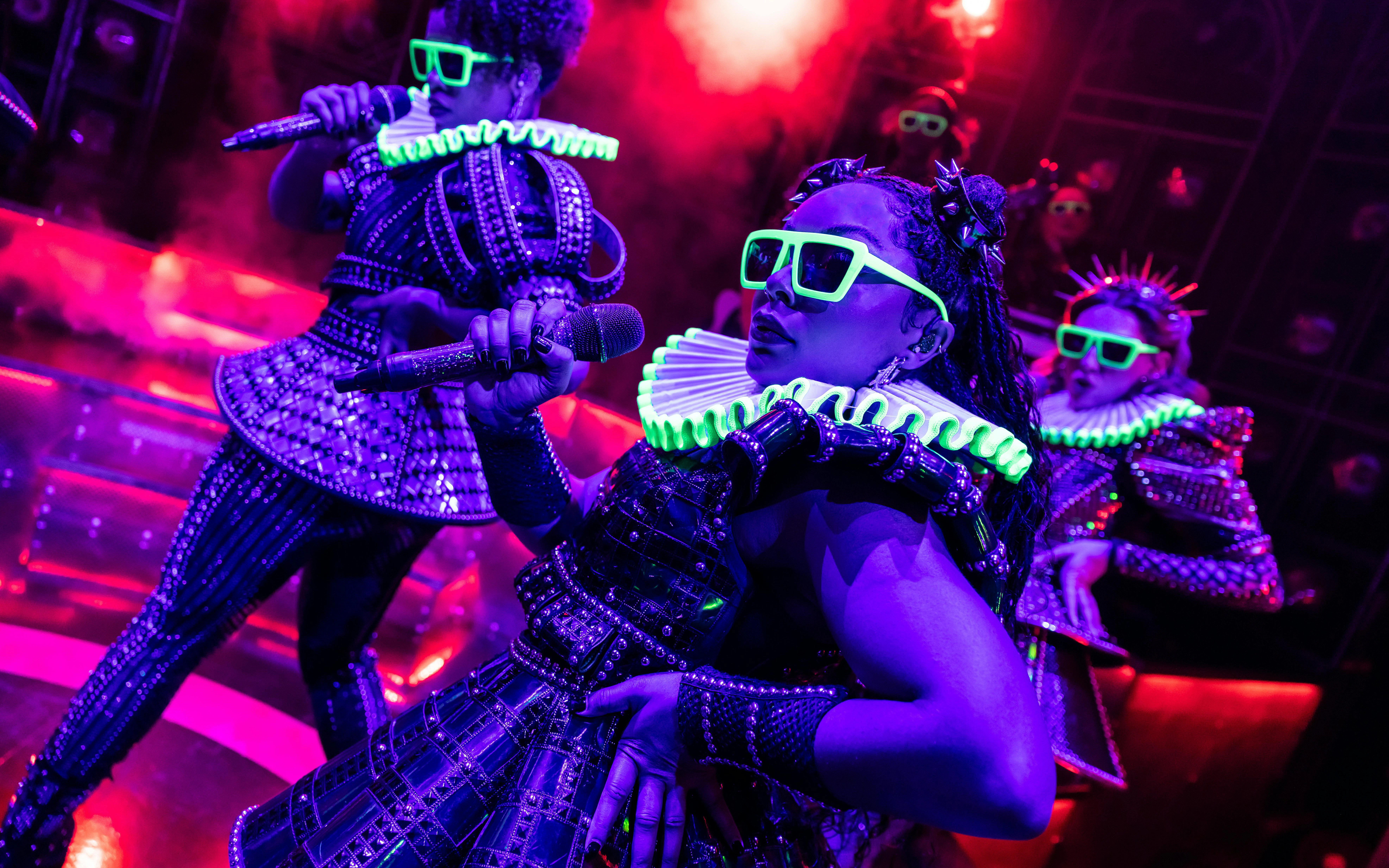 Performers in futuristic costumes on stage during Six musical in West End.