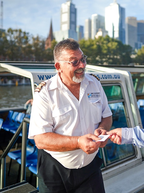 Cruise captain checking tickets of guests on Yarra River sightseeing cruise.