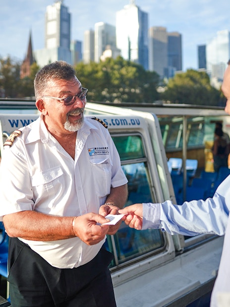 Cruise captain checking tickets of guests on Yarra River sightseeing cruise.