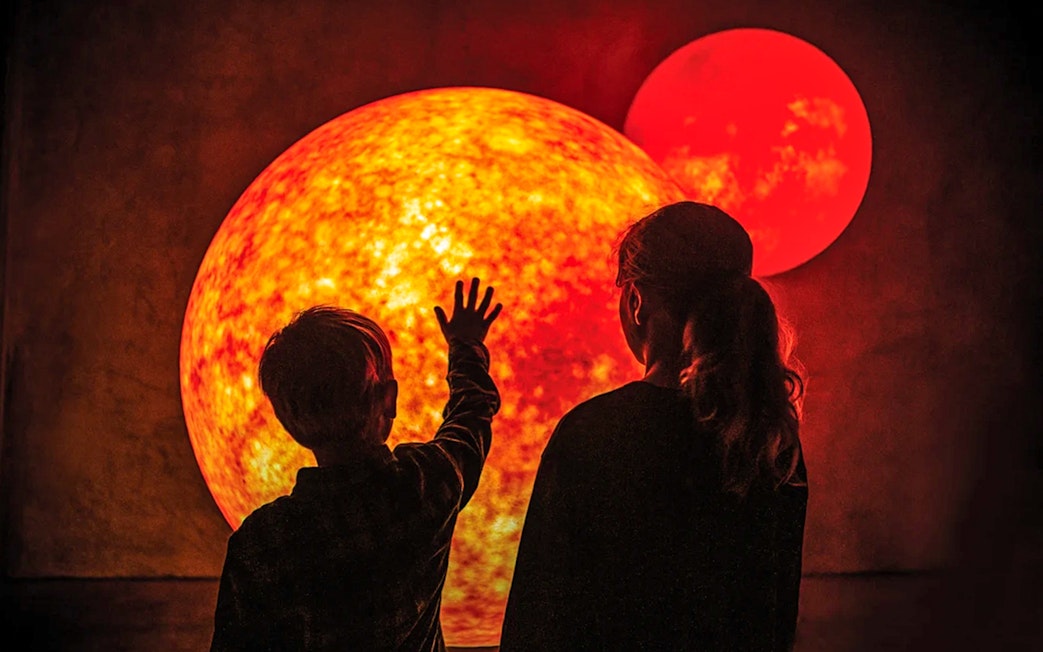 Children exploring solar system display at Dark Sky Indoor Cultural Astronomy Experience.