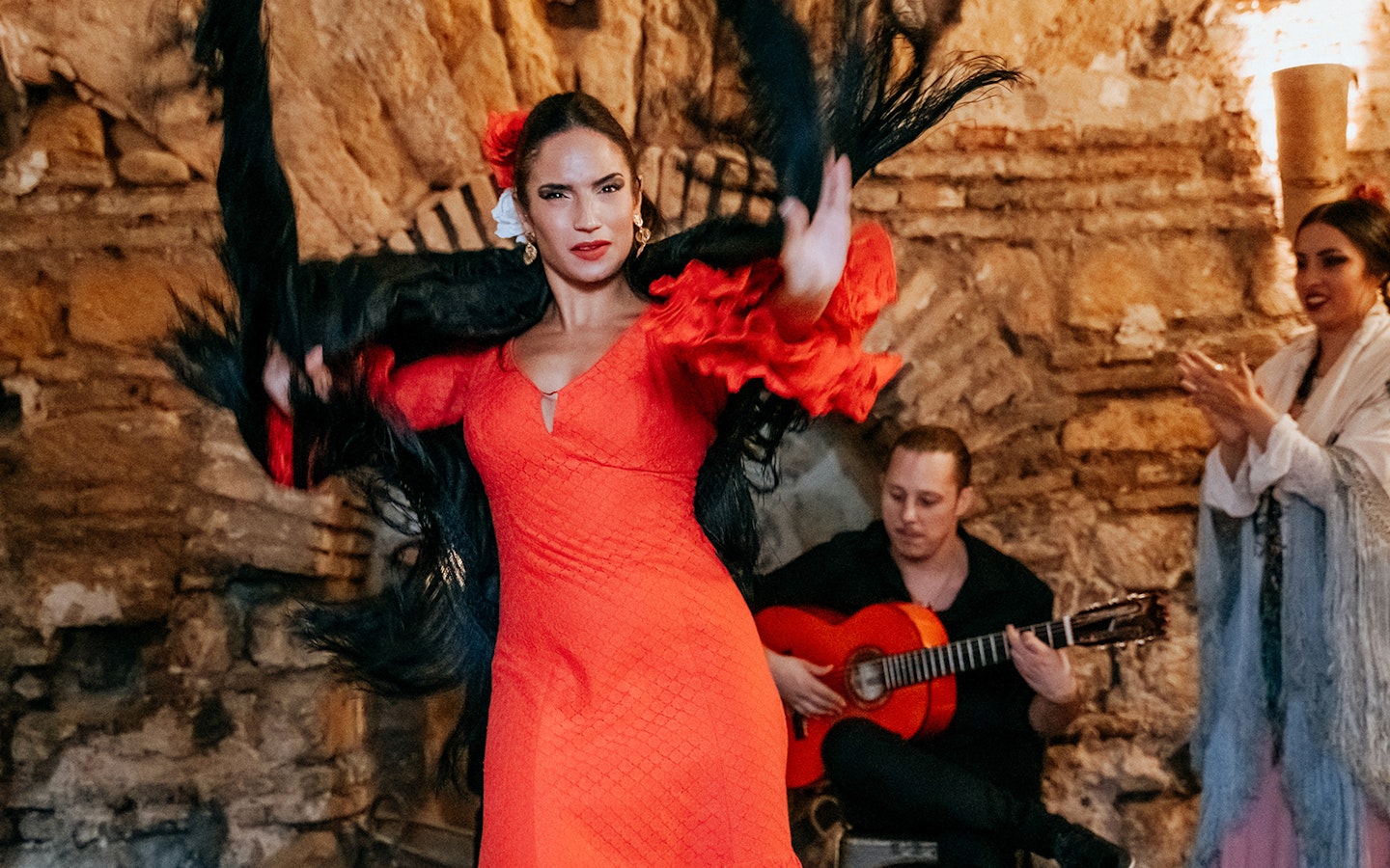 Flamenco dancer performing at Tablao en Baños Árabes de Santa María with guitarist in background.