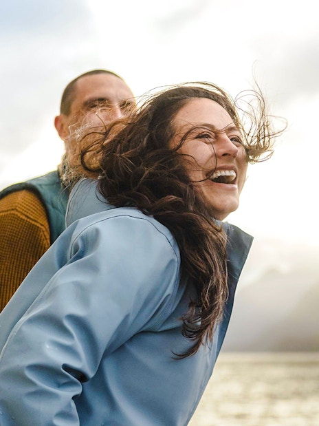 Couple enjoying a Doubtful Sound cruise with scenic mountain views.