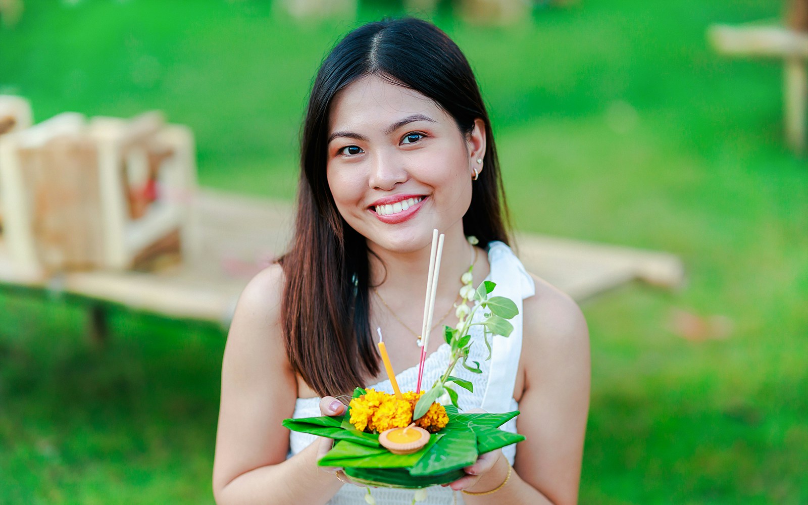 Woman holding a decorated krathong at Chiang Mai Sky Lanterns Festival, Thailand.