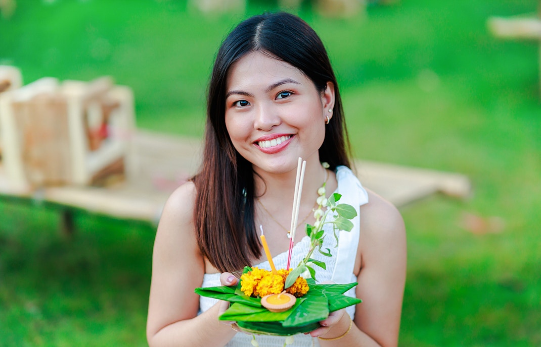Woman holding a decorated krathong at Chiang Mai Sky Lanterns Festival, Thailand.