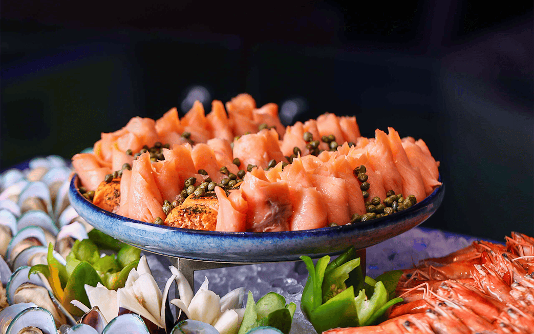Smoked salmon with capers on a platter, part of Petronas Twin Towers dining experience.