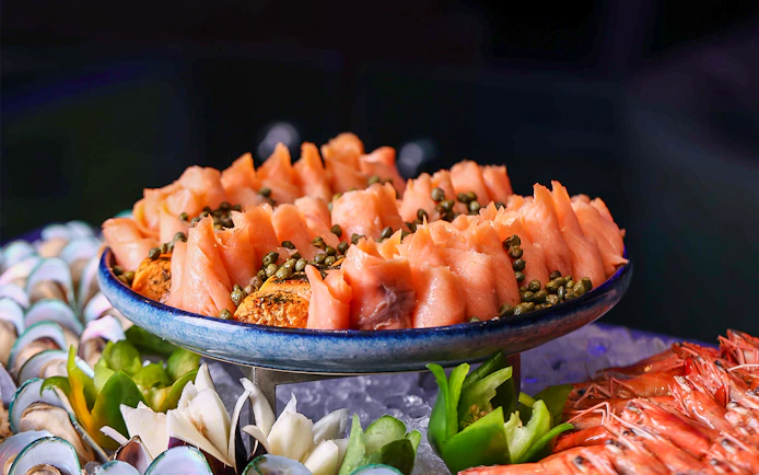 Smoked salmon with capers on a platter, part of Petronas Twin Towers dining experience.