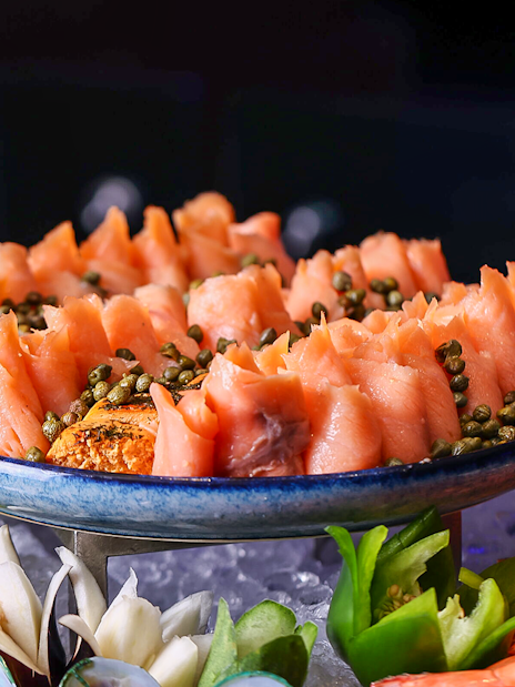 Smoked salmon with capers on a platter, part of Petronas Twin Towers dining experience.