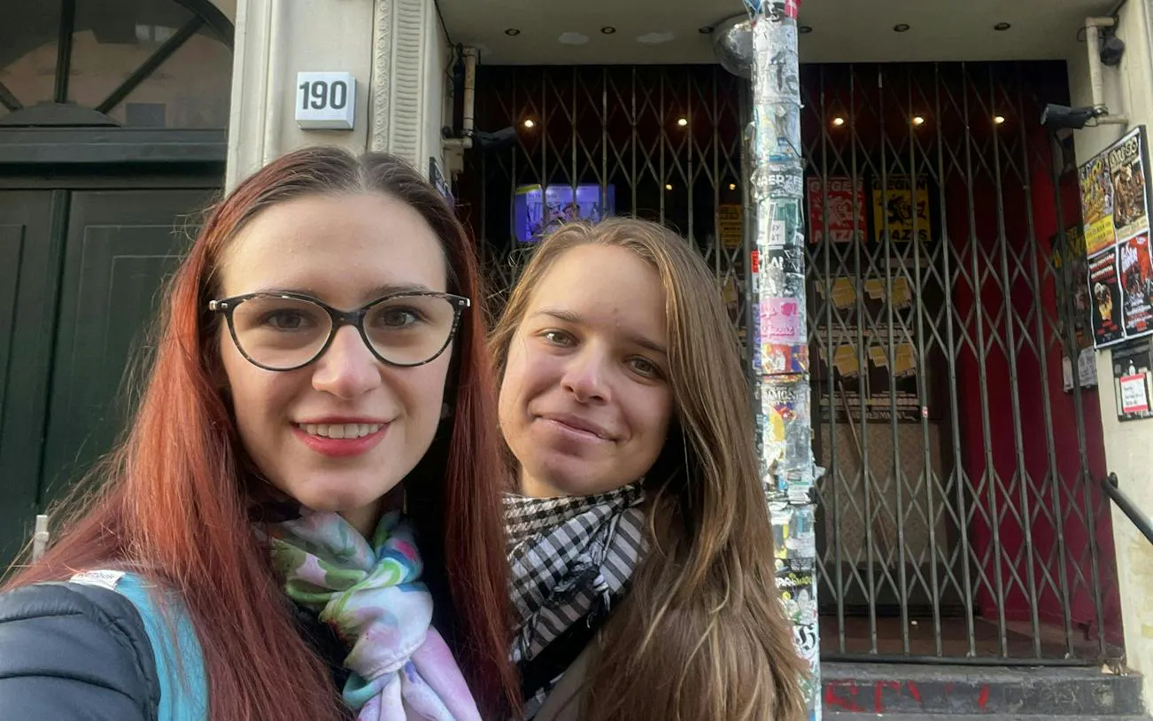 Two people in front of a graffiti-covered entrance in Berlin Kreuzberg.