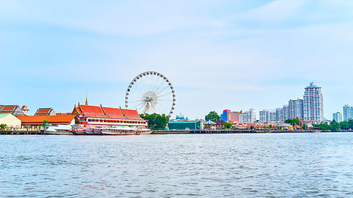 Asiatique Pier with ferris wheel and riverside buildings in Bangkok.