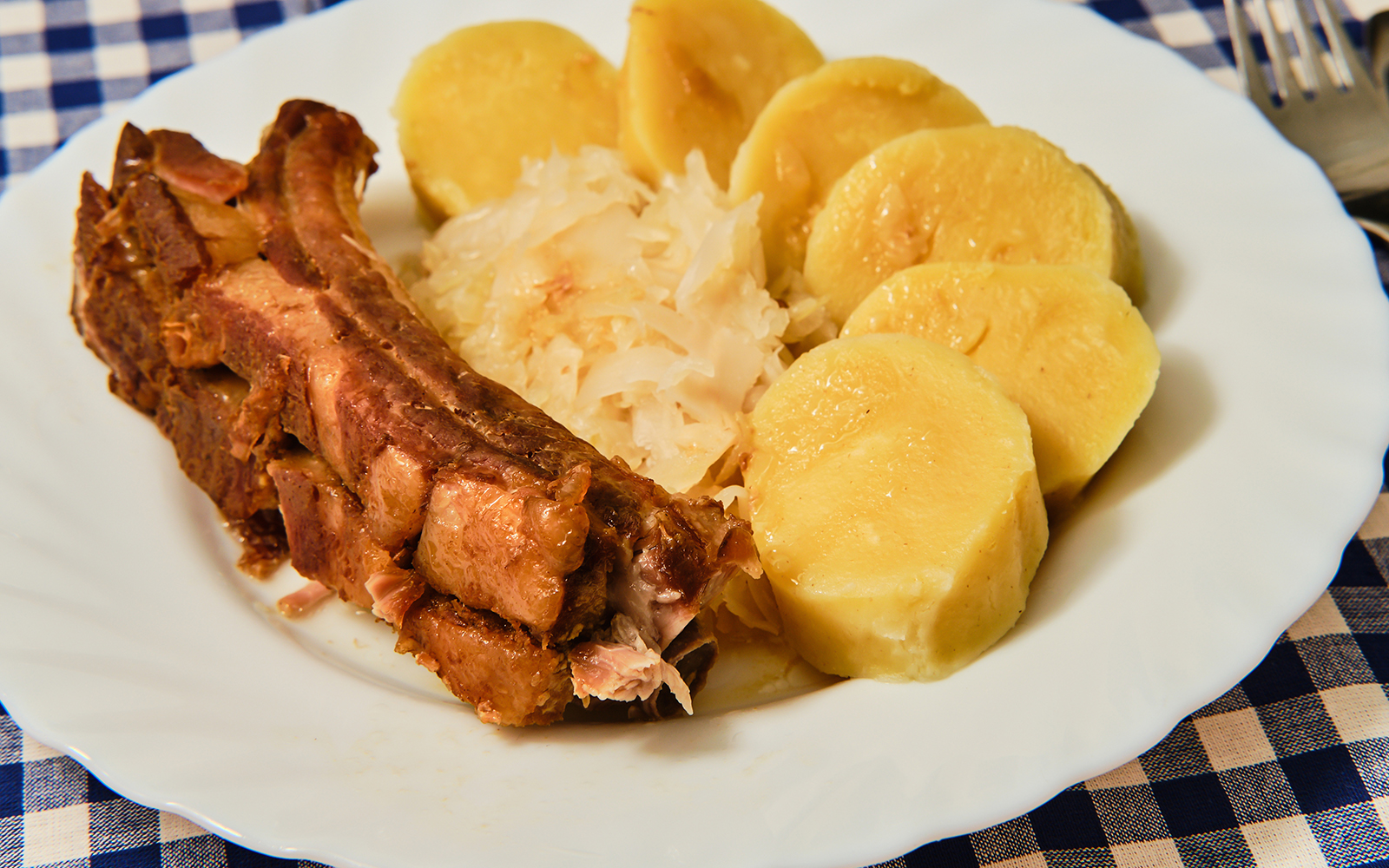 Traditional Czech dish knedlo vepro zelo with roast pork, dumplings, and sauerkraut.