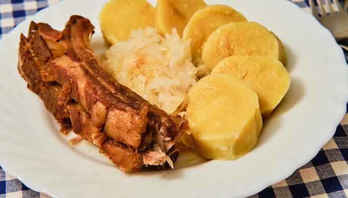 Traditional Czech dish knedlo vepro zelo with roast pork, dumplings, and sauerkraut.