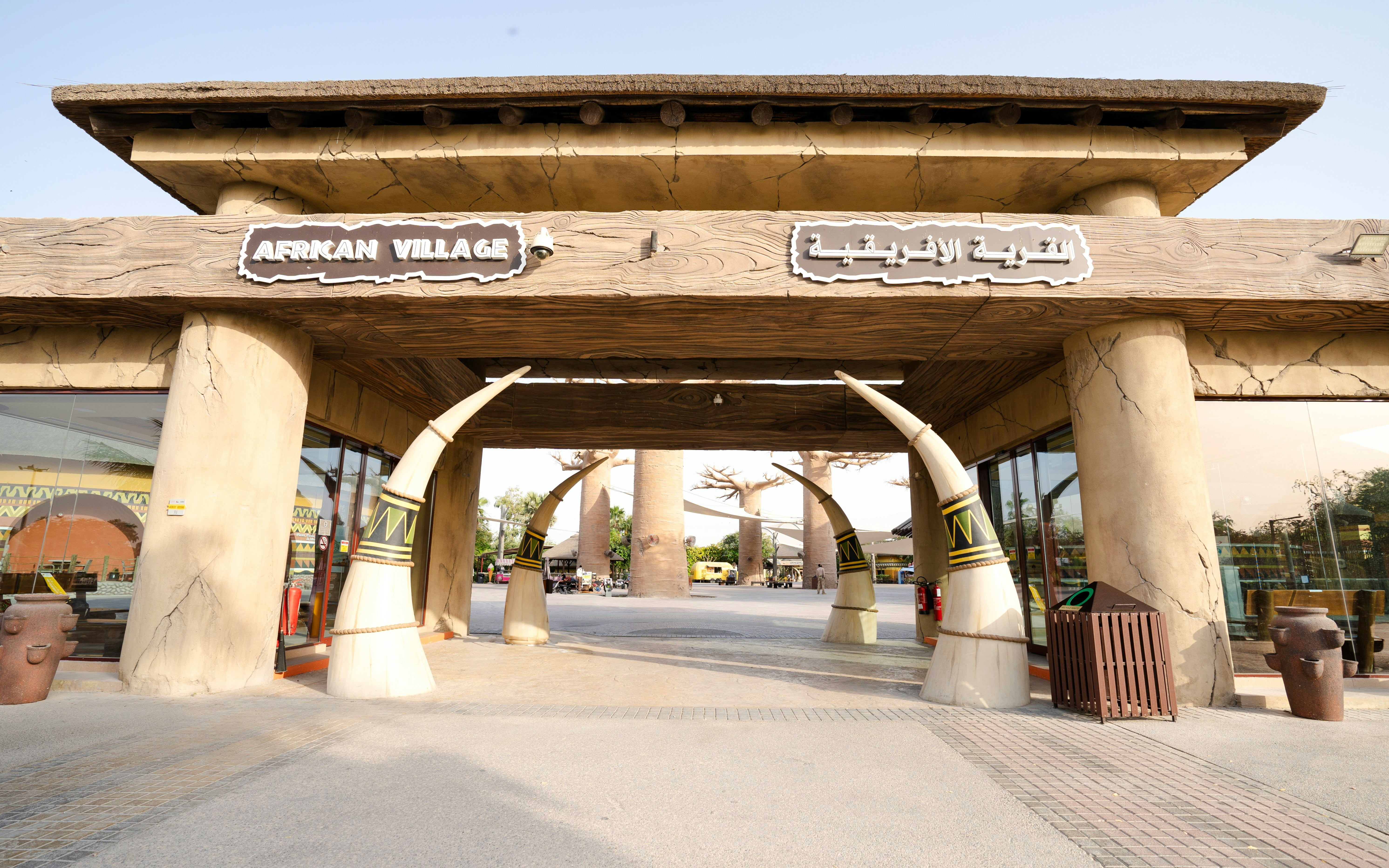 Entrance to African Village at Dubai Safari Park with tusk-shaped pillars.