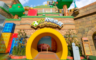 Yoshi's Adventure entrance at Universal Studios Japan with colorful blocks and trees.