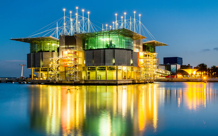 Lisbon Oceanarium illuminated at night, reflecting on the water, Lisbon Card.