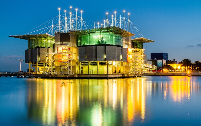 Lisbon Oceanarium illuminated at night, reflecting on the water, Lisbon Card.