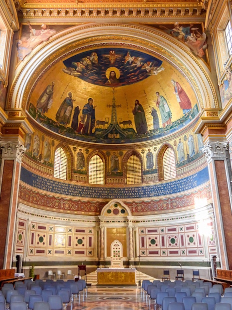 Interior of a Roman basilica with ornate frescoes and arches on the Appian Way tour.