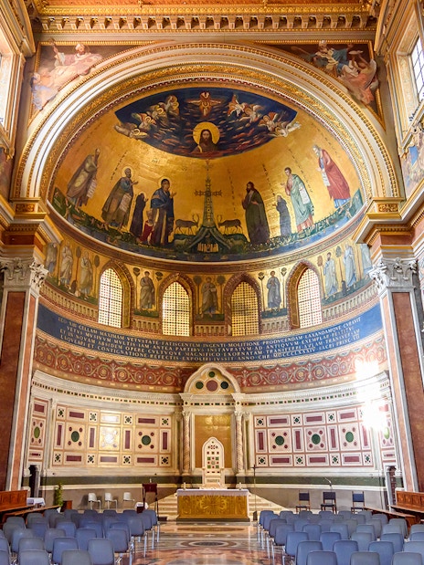 Interior of a Roman basilica with ornate frescoes and arches on the Appian Way tour.