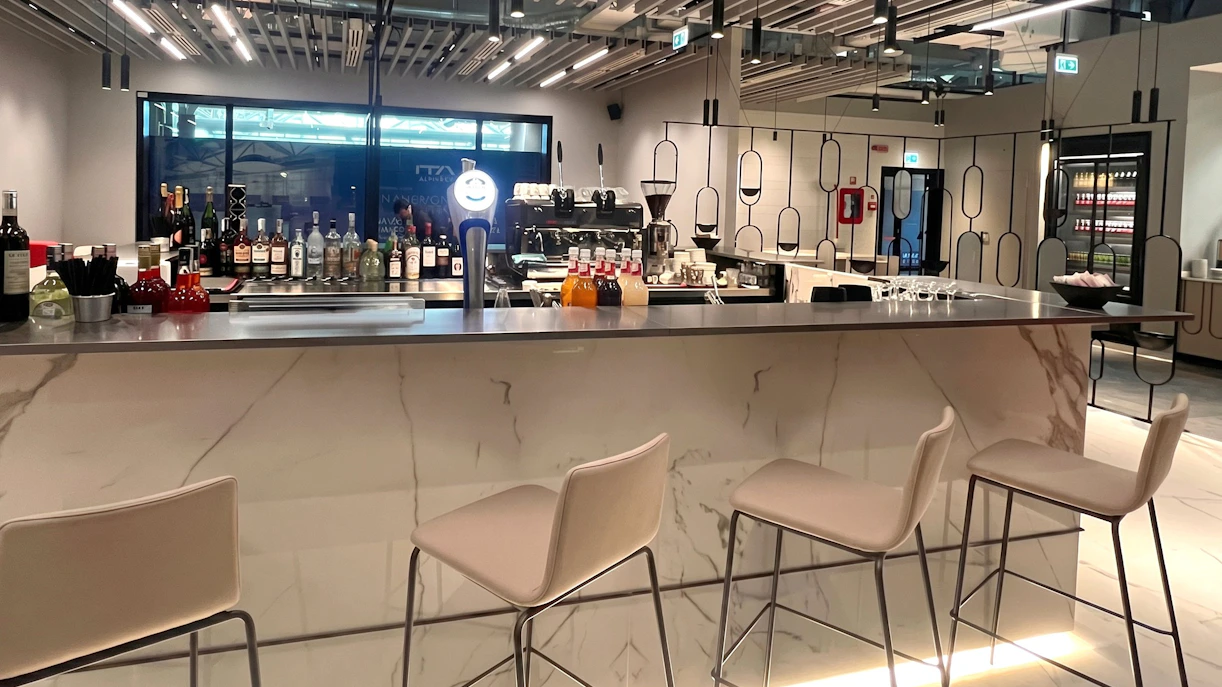 Bar area at Plaza Premium First Lounge, Rome Fiumicino Airport Terminal 1, with seating and drinks display.