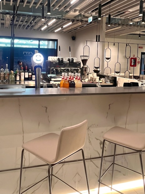 Bar area at Plaza Premium First Lounge, Rome Fiumicino Airport Terminal 1, with seating and drinks display.