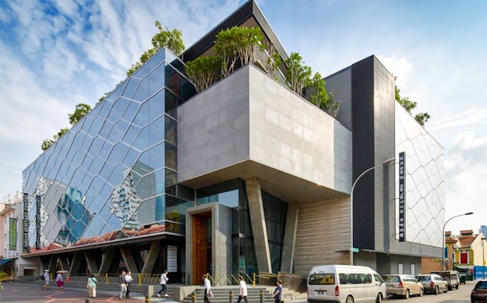 Modern glass and concrete facade of the Indian Heritage Centre in Singapore.