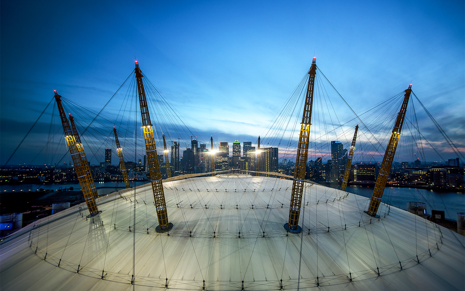 O2 Arena roof with city skyline at twilight, London.