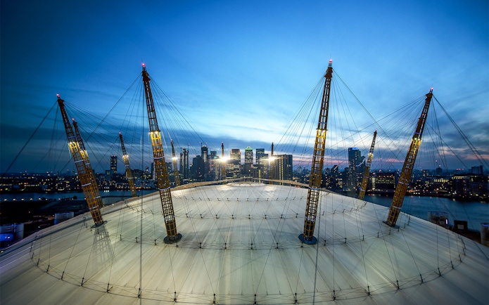 O2 Arena roof with city skyline at twilight, London.