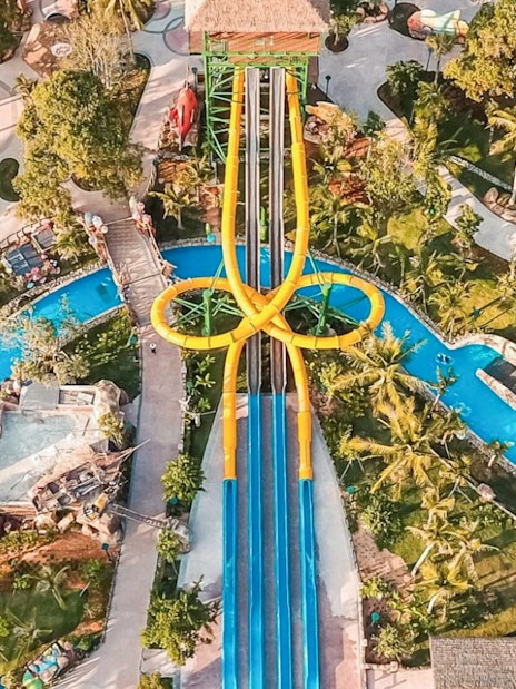 Aerial view of colorful waterslides at Sun World Hon Thom in Phu Quoc, surrounded by lush greenery.