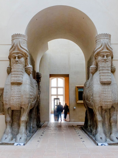 Lamassu statues at Louvre Museum entrance, Paris, France.