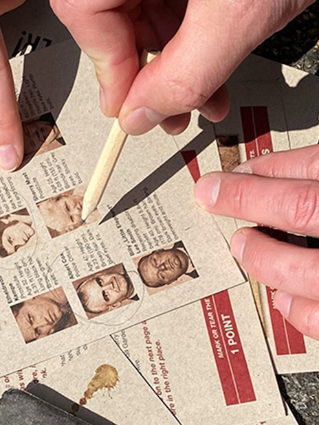 Clue-solving during murder mystery at Christiansborg Palace with suspect profiles.